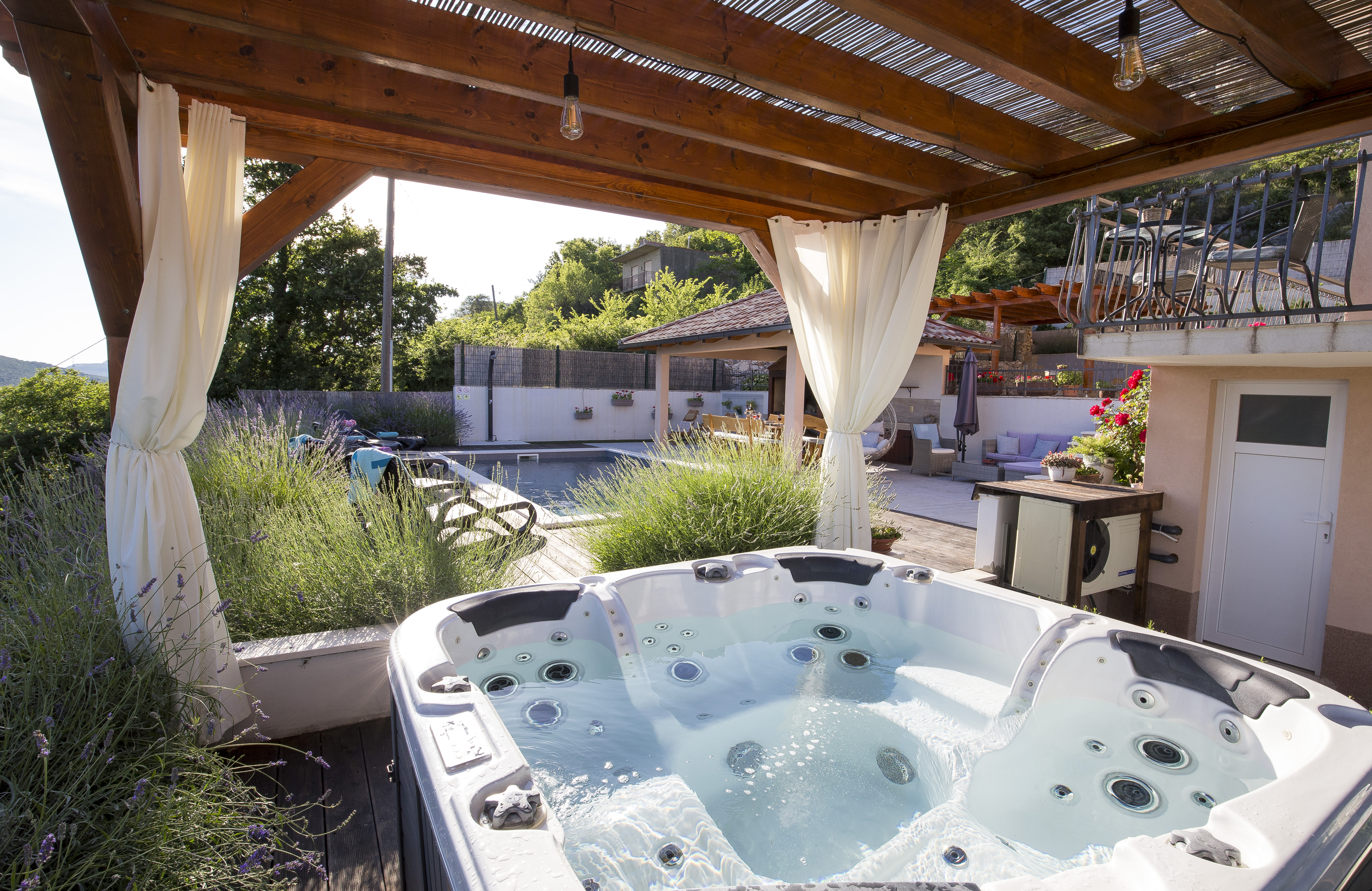 Jacuzzi under pergola with pool views